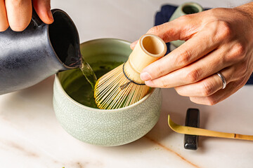 Man hands, Cooking green matcha tea during the Japanese ceremony. Traditiobal kit, Bamboo whisk and...