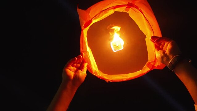Person launching sky paper lantern, Porto's S&atilde;o Jo&atilde;o night