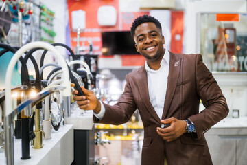 Portrait of buyer in bathroom store. Man is choosing faucet for his apartment.