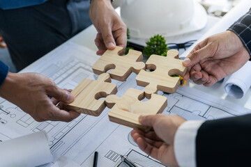 Business people with jigsaw puzzle pieces in office, Working on blueprint meeting for corporation business, Successful teamwork and partnership concept.