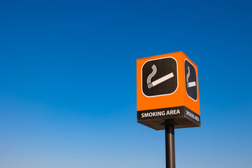 Smoking area signpost isolated on blue sky background