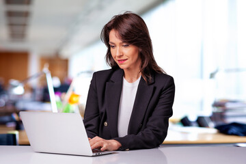 Executive businesswoman sitting at the office and using her laptop for work - 739796875