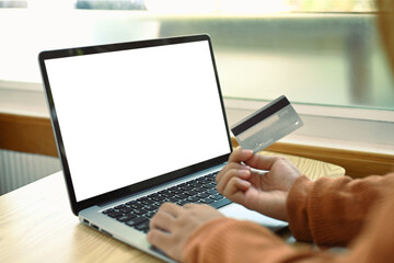 Cropped shot of young woman using credit card and laptop for shopping online