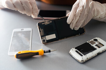 Technician repairing mobile phone at table, closeup