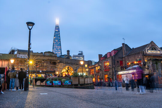 The Shard skyscraper (also referred to as the Shard London Bridge) above the city skyline and a busy street on an early evening