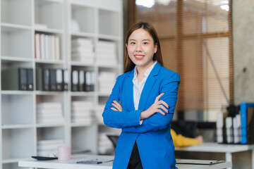 Two focused young Asian businesswomen or female accountants are discussing work, examining...