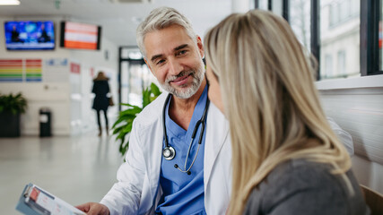 Pharmaceutical sales representative talking with doctor in modern clinic. Ambitious female medical...
