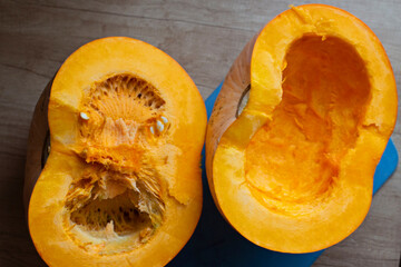 Large pumpkin cut into two halves on a wooden table. Healthy and healthy food. Pumpkin cross-section, top view