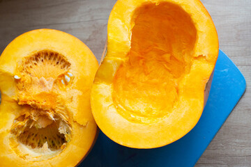 Cooking bright orange pumpkin lying on a cutting board. Cut pumpkin on the table. Growing vegetables.