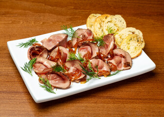 Roast beef with onions and croutons in a plate.