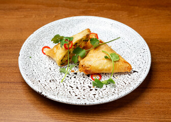 Samsa with chicken, baked goods in a plate.