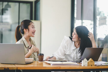 Team of diverse partners mature Latin business  woman discussing project on tablet sitting at table in office. Two colleagues of professional business people working together.