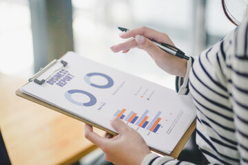 Team of diverse partners mature Latin business  woman discussing project on tablet sitting at table in office. Two colleagues of professional business people working together.