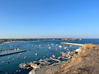 View to the small dock with yachts and boats, ocean coast, blue sky