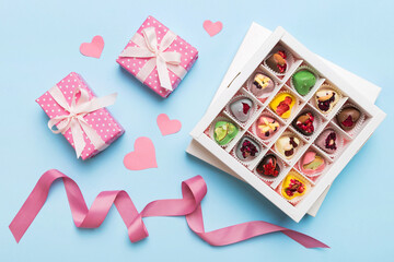 Valentine day composition: sweet candy, with gift boxes with bow and red felt hearts, photo template, background. Top View with copy space