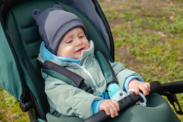 Surprised child in stroller in spring park