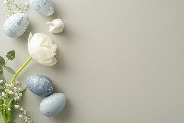 Easter aesthetic concept shown through top view slate greyish eggs, a bunny model, gypsophila, tulip, and eucalyptus, all organized on a pastel grey setting, leaving ample space for textual content