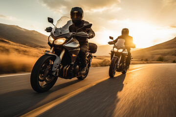 Two motorcyclists riding on a scenic open road at sunset