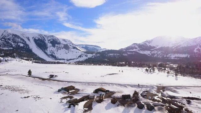 Mammoth Lakes Sierra Mountains California aerial cinematic drone flight winter spring sunny beautiful snow covered town June Lake Crowley Bishop skatepark open space cabins The Station upward movement