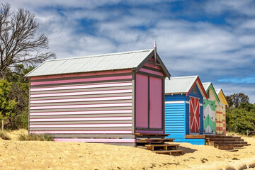 Brighton beach Victorian bathing boxes. Brightly painted colourful beach huts line the sand in Melbourne, Australia. They are highly desirable and extremely expensive real estate. - 739833864