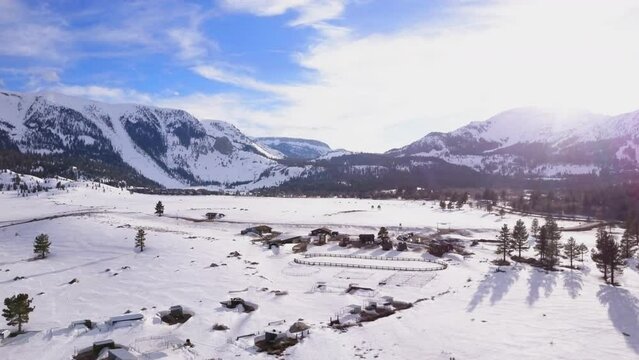 Mammoth Lakes Sierra Mountains California aerial cinematic drone flight winter spring sunny beautiful snow covered town June Lake Crowley Bishop The Station skatepark forward movement