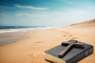 Bible book, wooden cross on sandy beach