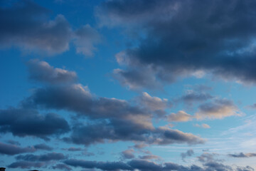 Naklejka na ściany i meble Cloudscape on a blue sky at sunset, background