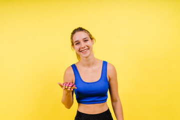 Portrait of beautiful female with chocolate donuts enjoying and looking at camera