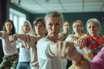 Fotobehang Group of Determined Women of Various Ages in a Self-Defense Class © KirKam