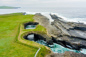 Aerial view of Bridges of Ross, three natural rock arches, carved into the cliffs by ocean erosion,...