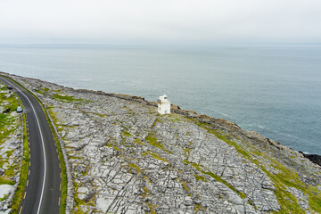 Black Head Lighthouse, situated in the rough landscape of Burren, amidst a bizarre scenery of steep...