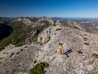 A woman standing on a rocky point overlooking Mediterranean sea, Malla del Llop peak, Alicante, Costa Blanca, Spain - stock photo