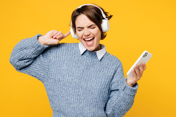 Young fun woman she wear grey knitted sweater shirt casual clothes listen to music in headphones...