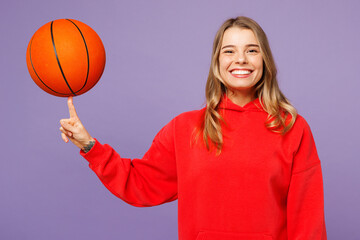 Young cheerful smiling woman fan wear red hoody cheer up support basketball sport team hold in hand...