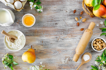 Ingredients for making buns or pies with jam and fresh pears on a wooden background. Top view. Copy...