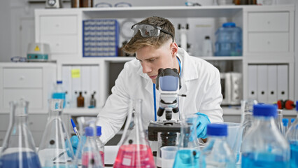 Handsome caucasian man, young and studious scientist at work in his lab! engrossed in medical...