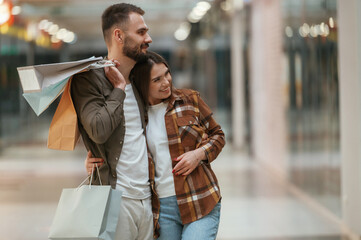 Embracing each other. Young couple are in supermarket together