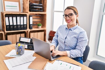 Fototapeta premium Young beautiful hispanic woman business worker using laptop working at office