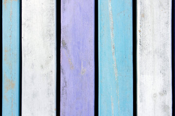 Background from wooden boards in pastel colors. Close-up of wooden boards painted in white, blue, and purple colors. Color background with space for text. Vintage board, multi-colored wood background