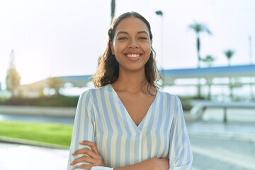 Young african american woman standing with arms crossed gesture at coffee shop terrace