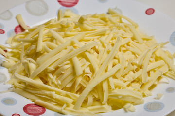 grated mozzarella on a plate, seen close up.
