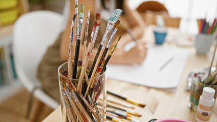 Passionate hispanic woman artist's hands drawing in art studio notebook amidst a creative rush