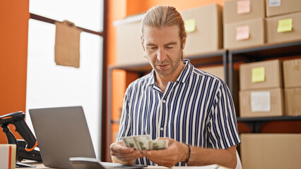 A middle-aged man counts money at his warehouse job, depicting a business and finance theme in an...
