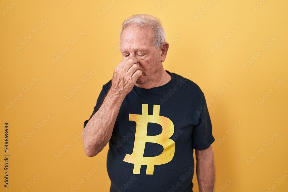 Sticker Senior man with grey hair wearing bitcoin t shirt tired rubbing nose and eyes feeling fatigue and headache. stress and frustration concept.