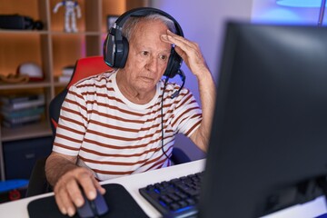 Middle age grey-haired man streamer stressed using computer at gaming room