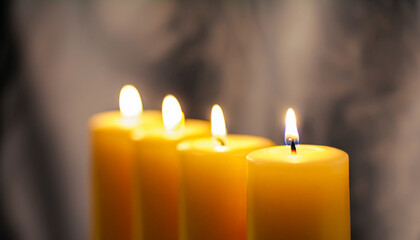 Close up of yellow candles with shallow focus and a soft dark backdrop