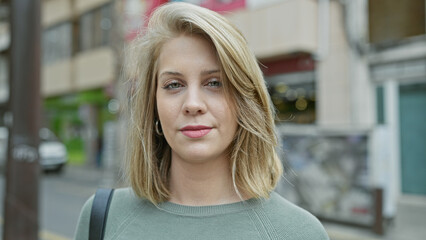 Portrait of a beautiful young adult blonde woman on an urban city street.