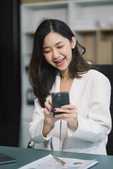 Business woman uses mobile phone to chat with friends during her free time.