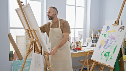 Handsome young man artist intensely drawing at his relaxed art studio, a creativity class bursting...