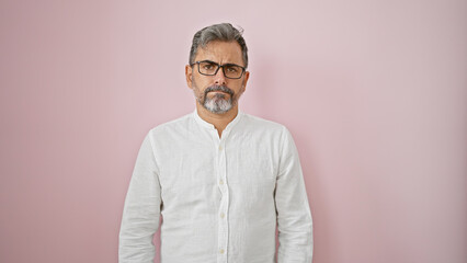 Chill vibes overload! young grey-haired hispanic man oozes cool, relaxed expression while standing, isolated over pink background. definitely that handsome adult male, rocking casual fashion! - obrazy, fototapety, plakaty